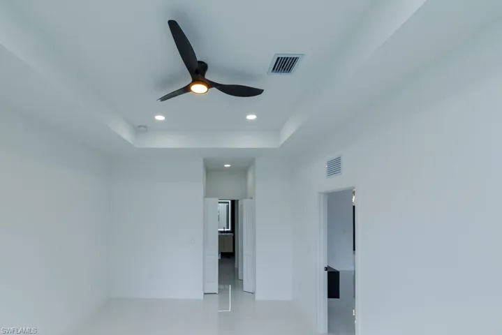 Unfurnished bedroom with baseboards, visible vents, recessed lighting, and a raised ceiling