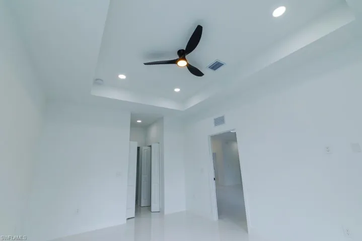Spare room with visible vents, baseboards, ceiling fan, recessed lighting, and a raised ceiling