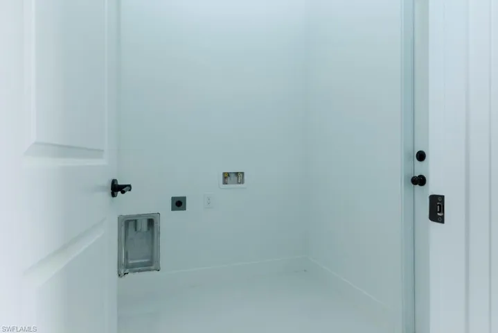 Laundry room featuring baseboards, hookup for an electric dryer, washer hookup, and laundry area