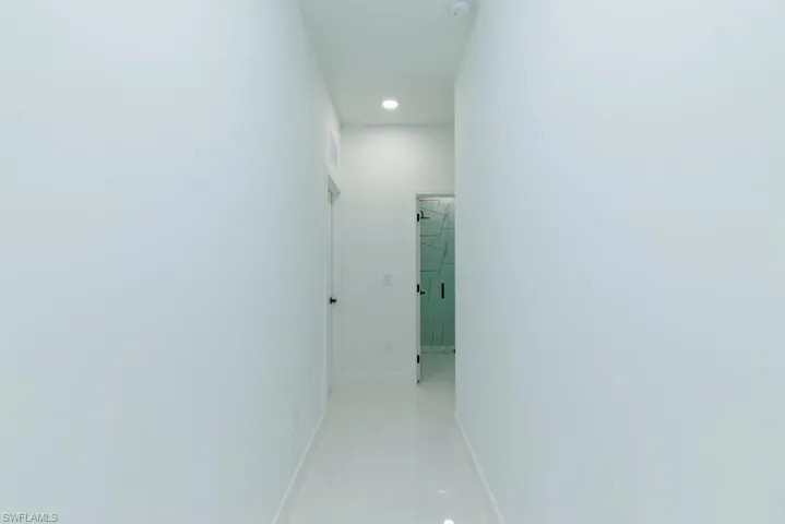 Corridor with baseboards and recessed lighting