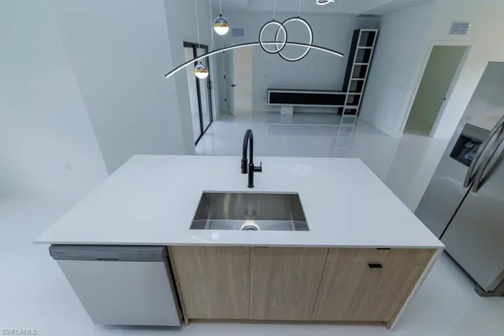 Kitchen with dishwasher, a sink, modern cabinets, and stainless steel fridge with ice dispenser