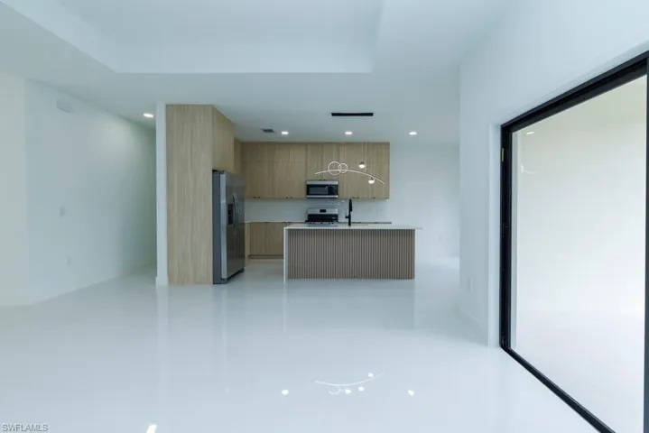 Kitchen with light countertops, a sink, appliances with stainless steel finishes, modern cabinets, and recessed lighting