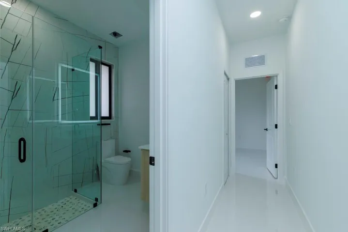 Full bathroom with a stall shower, visible vents, toilet, and recessed lighting