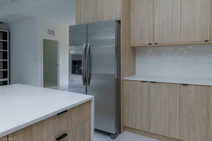 Kitchen featuring stainless steel fridge, modern cabinets, and light brown cabinetry