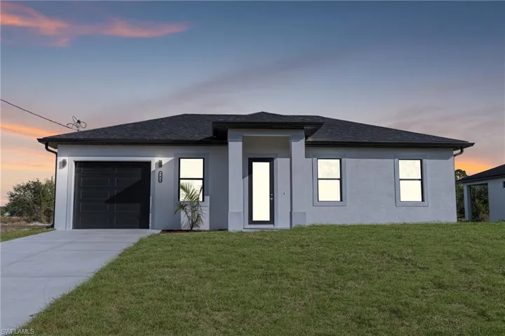 View of front facade with a garage and a yard