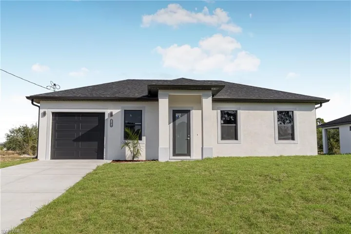 View of front facade with a garage and a front lawn