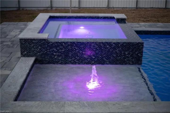 Outdoor pool with an in-ground hot tub and a patio area