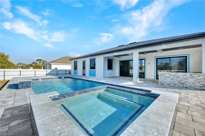 Integrated pool / hot tub featuring a patio area and a fenced backyard