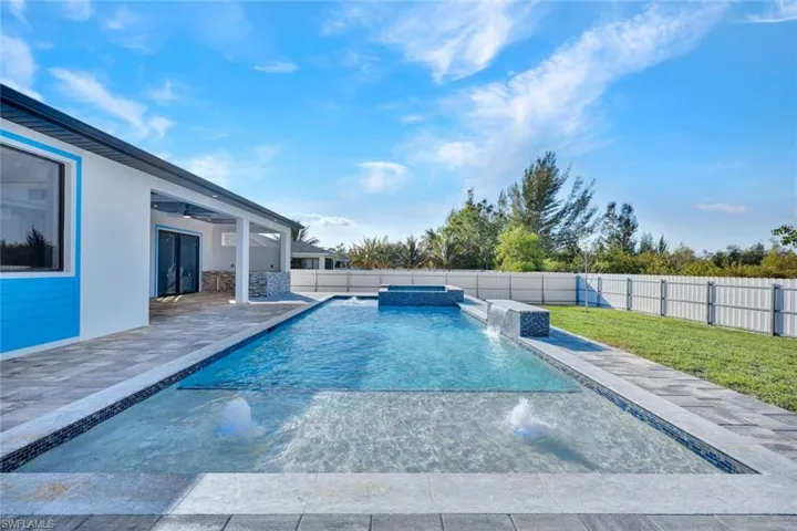 Integrated pool / spa with a patio and a fenced backyard