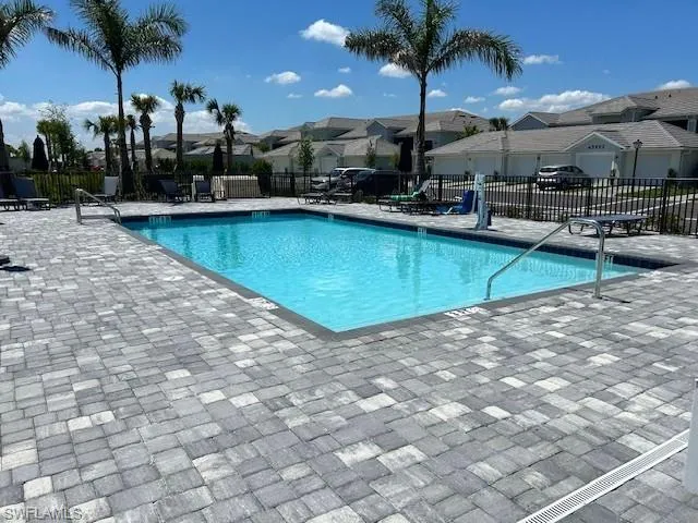 Pool featuring a residential view, fence, and a patio area for grilling