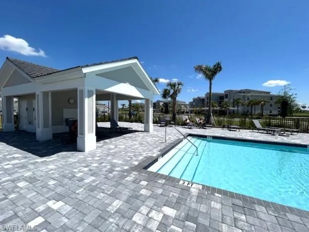 Community pool featuring fence and a patio area
