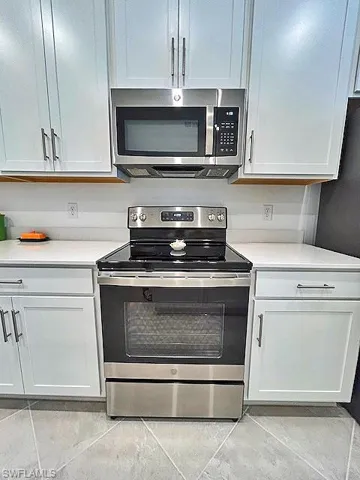 Kitchen with white cabinetry, Quartz countertops, and stainless steel appliances.