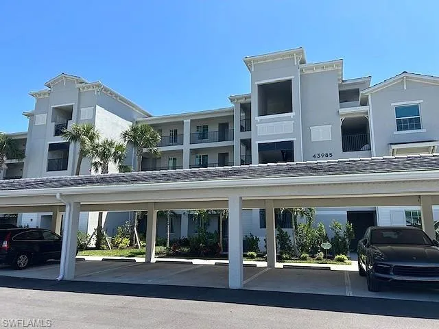 View of building exterior with covered parking. Deeded parking spot