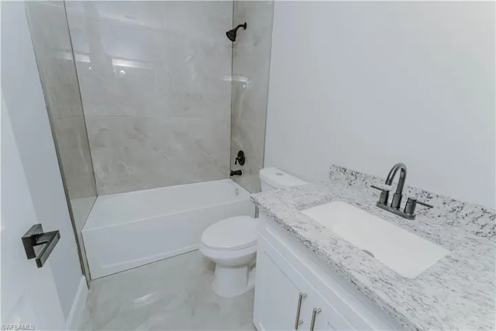 Full bathroom featuring vanity, shower / tub combination, and toilet