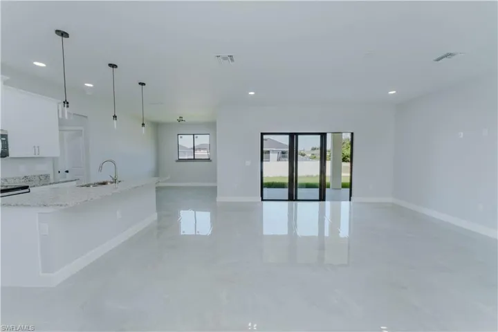 Kitchen with open floor plan, a kitchen island with sink, a sink, and visible vents