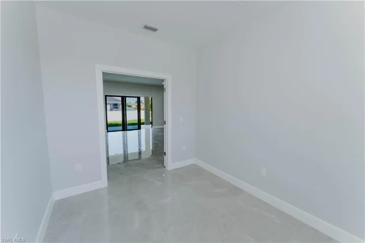 Empty room with marble finish floor, baseboards, and visible vents