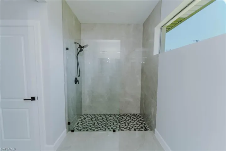 Full bath featuring baseboards and a tile shower