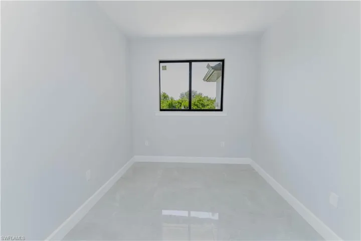 Spare room featuring marble finish floor and baseboards