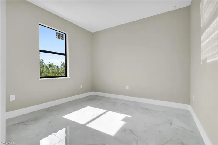 Spare room with marble finish floors and baseboards