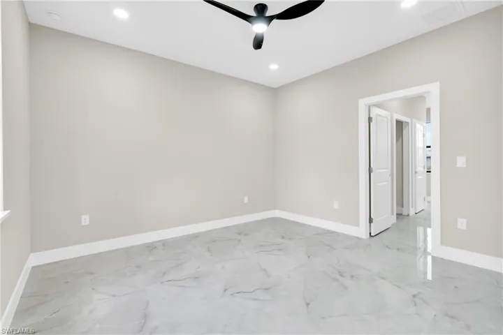 Spare room with light marble finish flooring, a ceiling fan, baseboards, and recessed lighting
