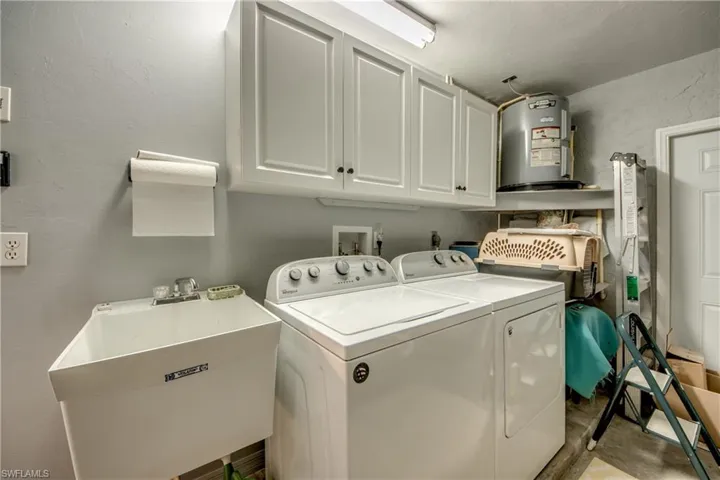 LAUNDRY WITH UPPER CABINETS AND TUB.