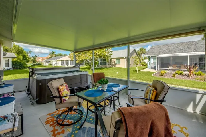 LANAI UNDER WHITE ALUMINUM ROOF.  ROLL DOWN SHADES.