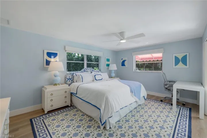 Bedroom featuring light hardwood / wood-style flooring, multiple windows, and ceiling fan