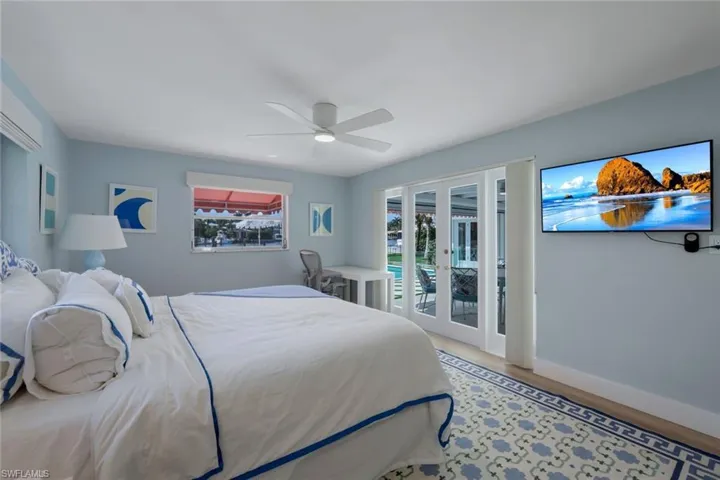 Bedroom with hardwood / wood-style floors, access to outside, french doors, and ceiling fan