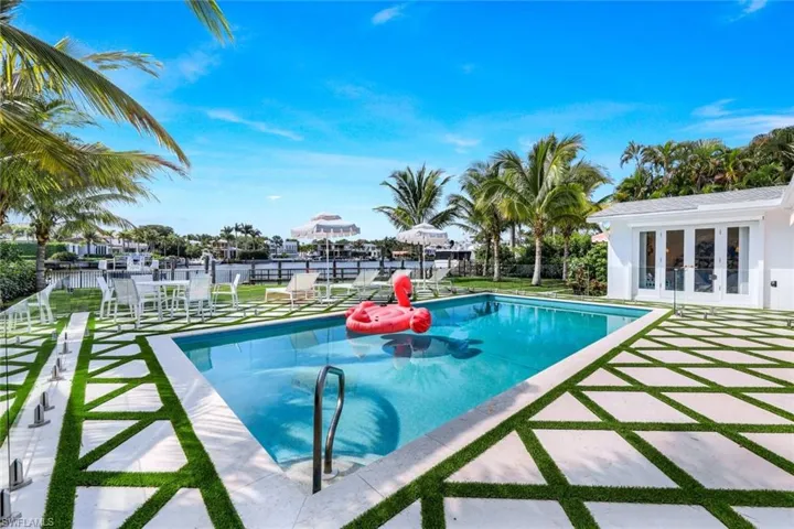 View of swimming pool featuring a patio, a water view, and french doors
