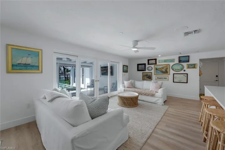 Living room with ceiling fan, french doors, and light hardwood / wood-style floors