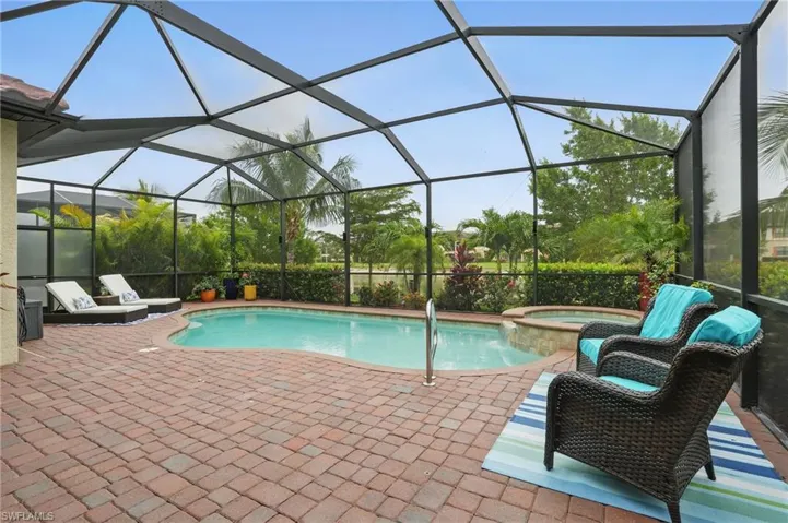 View of pool featuring a patio, a pool with connected hot tub, and a lanai