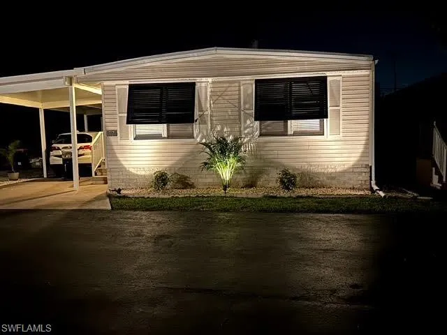 View at night of front of house with a carport