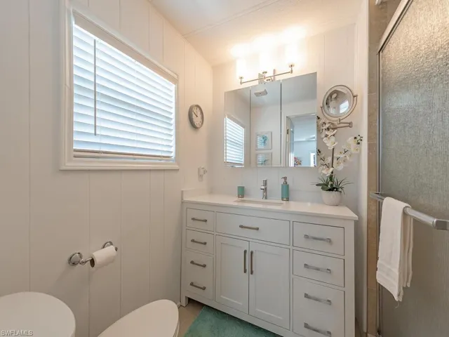 Full bath featuring toilet, an enclosed shower, and vanity