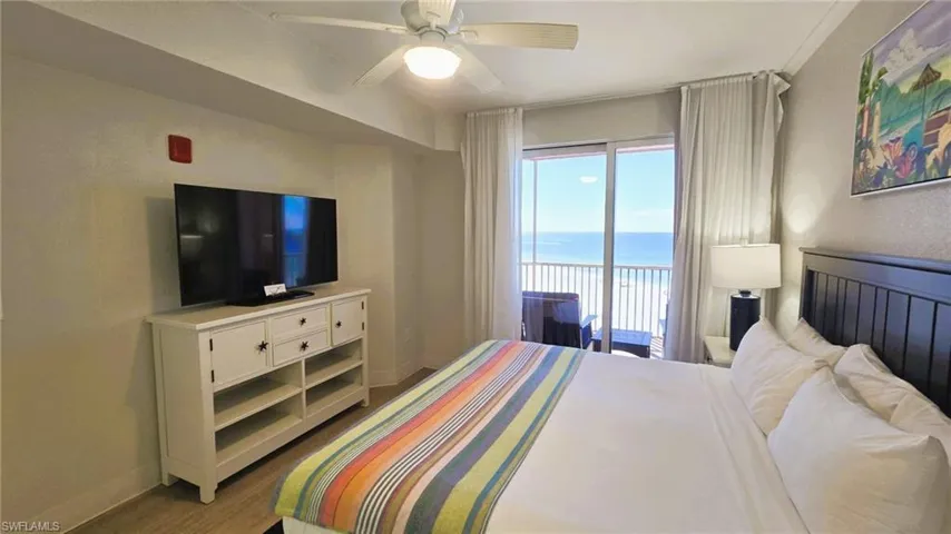 Bedroom with wood finished floors, access to outside, and ceiling fan