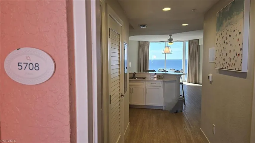 Hallway with a textured wall, wood-style flooring, recessed lighting, and a water view