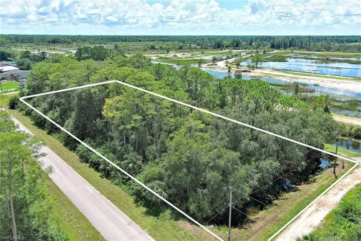 Aerial overview of property's location with property parcel outlined and a large body of water