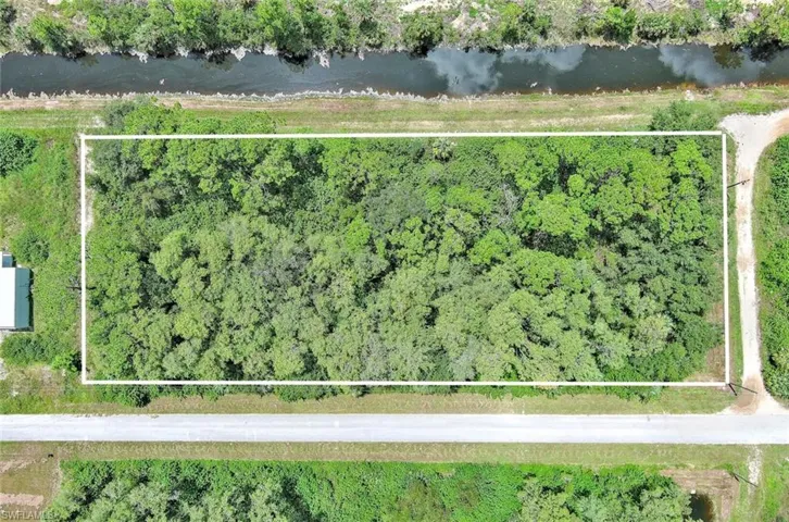 Aerial view of property and surrounding area featuring property parcel outlined