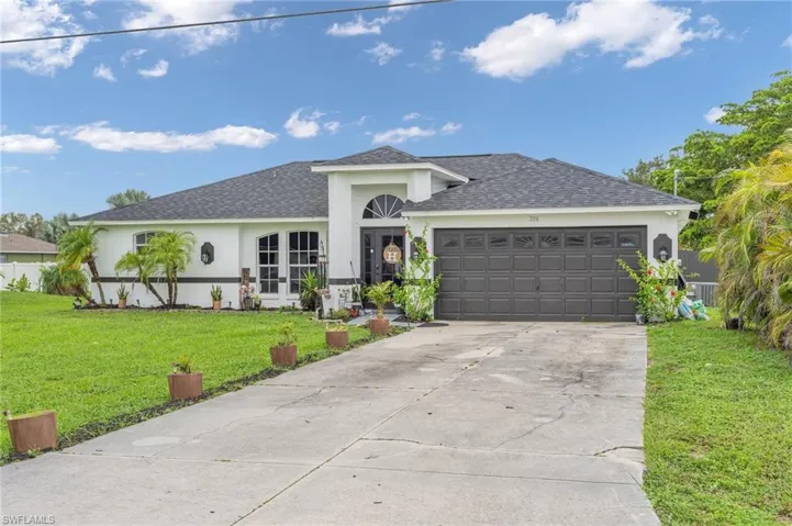 View of front of property featuring a garage and a front lawn