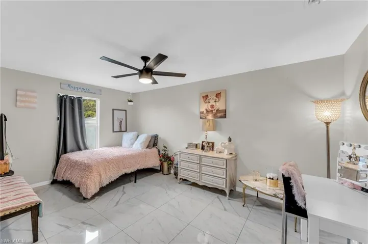 Bedroom with light tile patterned flooring and ceiling fan