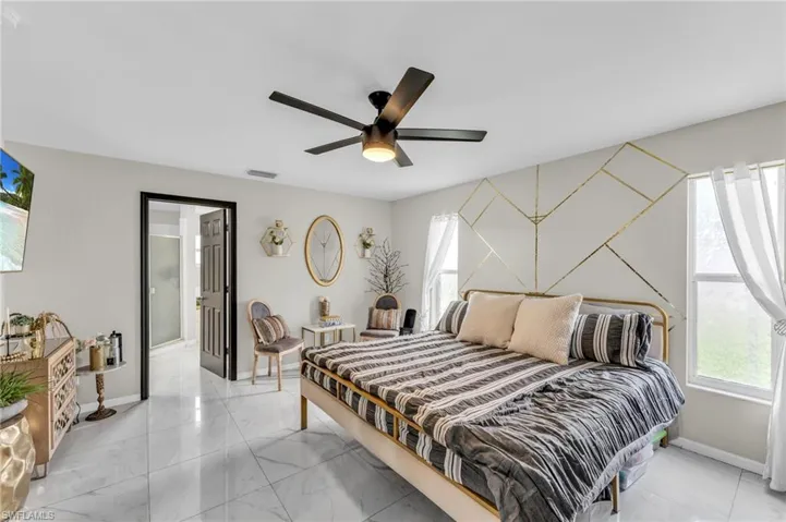 Tiled bedroom featuring ceiling fan