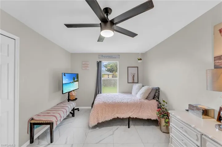 Bedroom with light tile patterned floors and ceiling fan