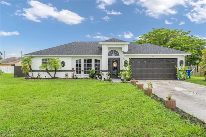 View of front facade featuring a garage and a front yard