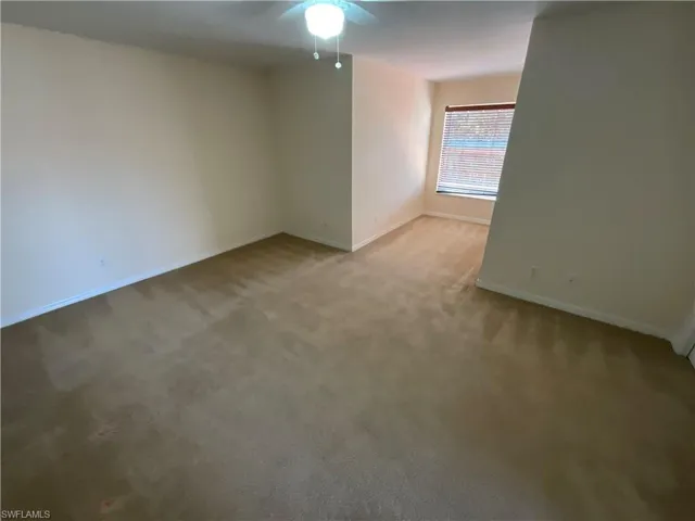 Spare room featuring carpet and ceiling fan