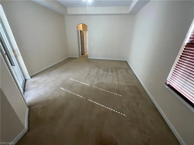 Empty room featuring carpet and a raised ceiling