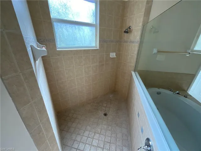 Bathroom featuring shower with separate bathtub