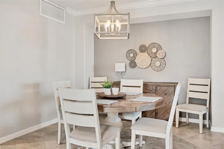 Dining space with a chandelier and crown molding