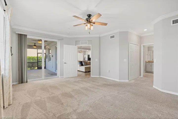 Unfurnished bedroom featuring crown molding, light carpet, access to outside, ensuite bathroom, and a ceiling fan