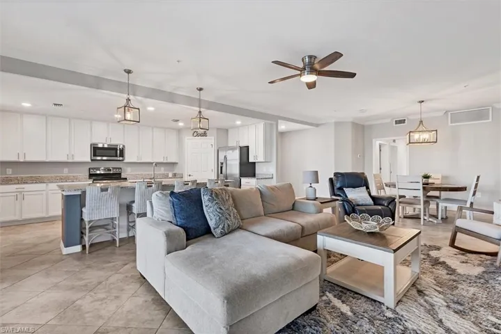 Living room featuring a ceiling fan, crown molding, recessed lighting, and light tile patterned floors