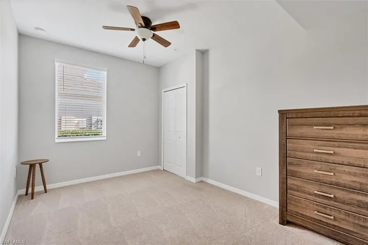 Unfurnished bedroom featuring light colored carpet, a ceiling fan, and a closet