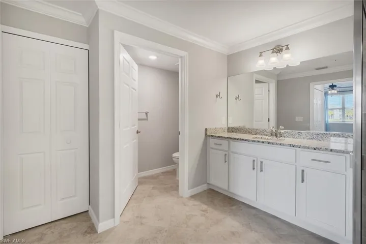 Full bathroom featuring a closet, crown molding, vanity, and ceiling fan